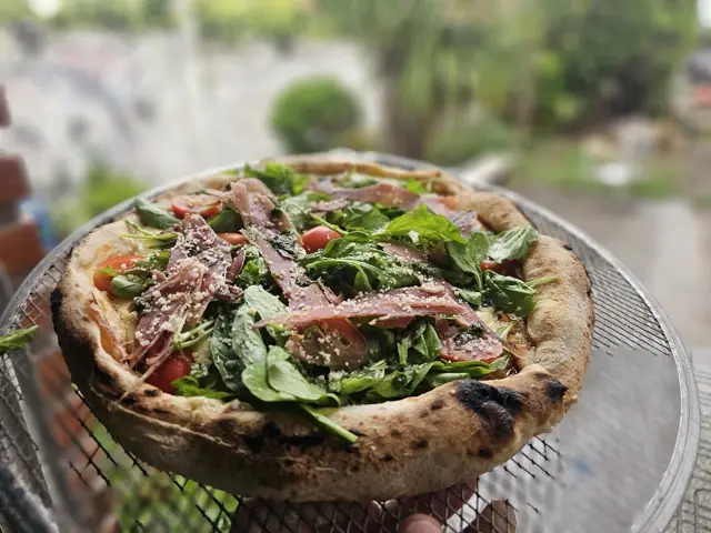 Pizza napolitana de rúcula y jamón crudo
